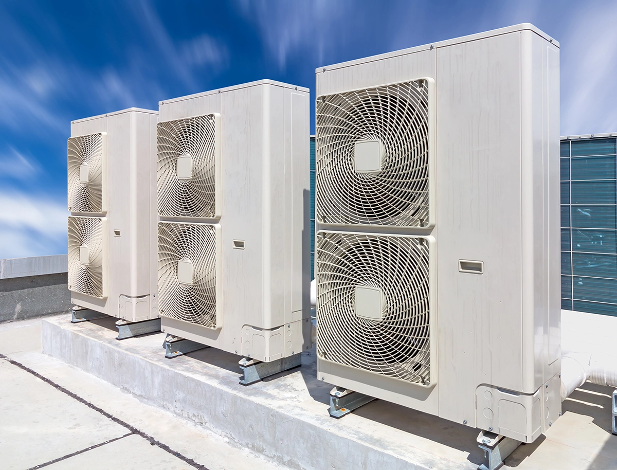 Multiple outdoor HVAC condenser units installed on a rooftop commercial building. Best for blogs about VRF HVAC, ductless commercial systems, commercial heat pumps, multi-zone HVAC, HVAC replacement for commercial buildings, and energy-efficient commercial cooling.